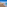 a beach with buildings and blue water
