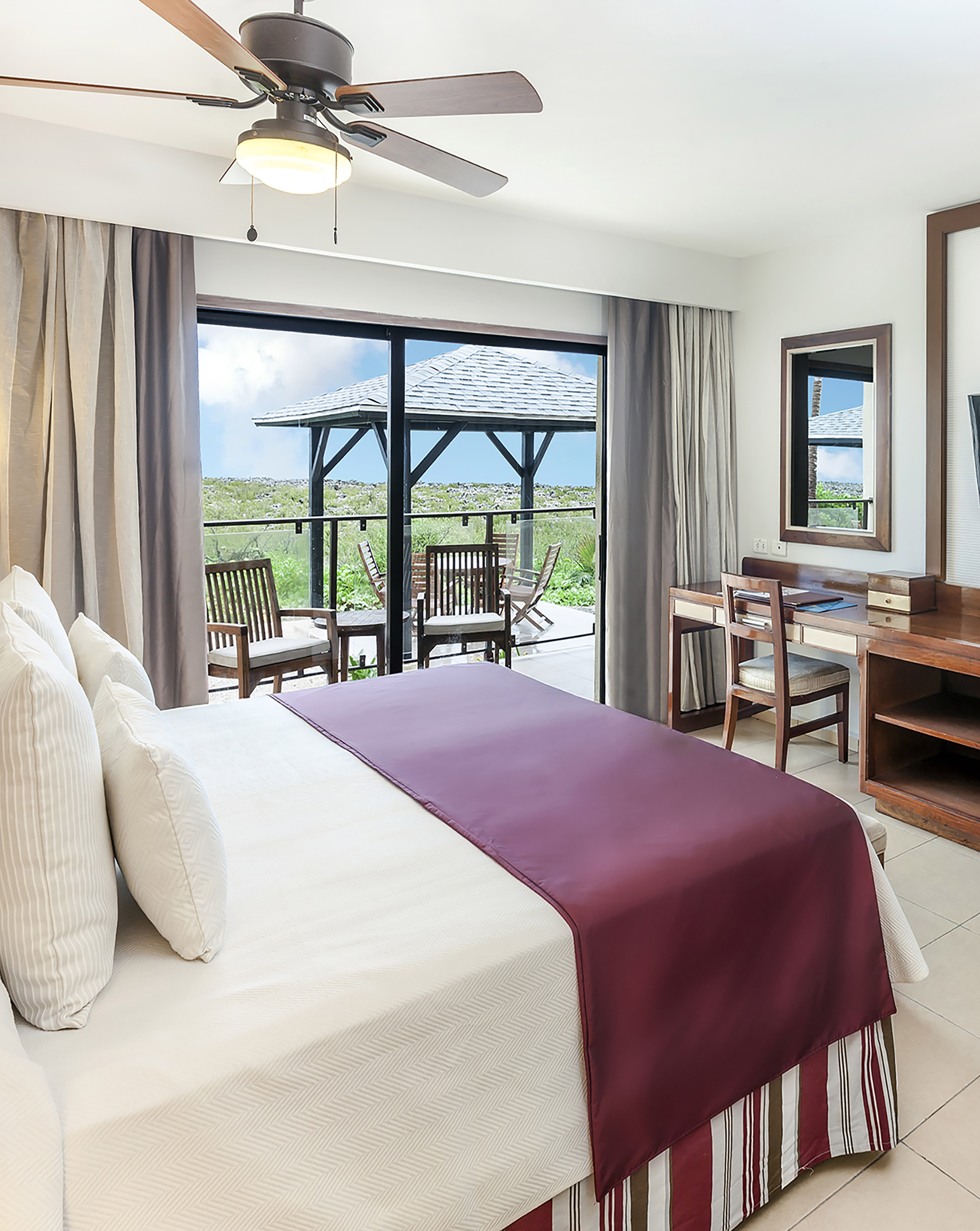 a bedroom with a large window and a table