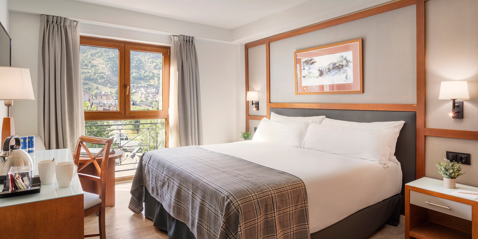 a bed with a chair and a table in a room with windows