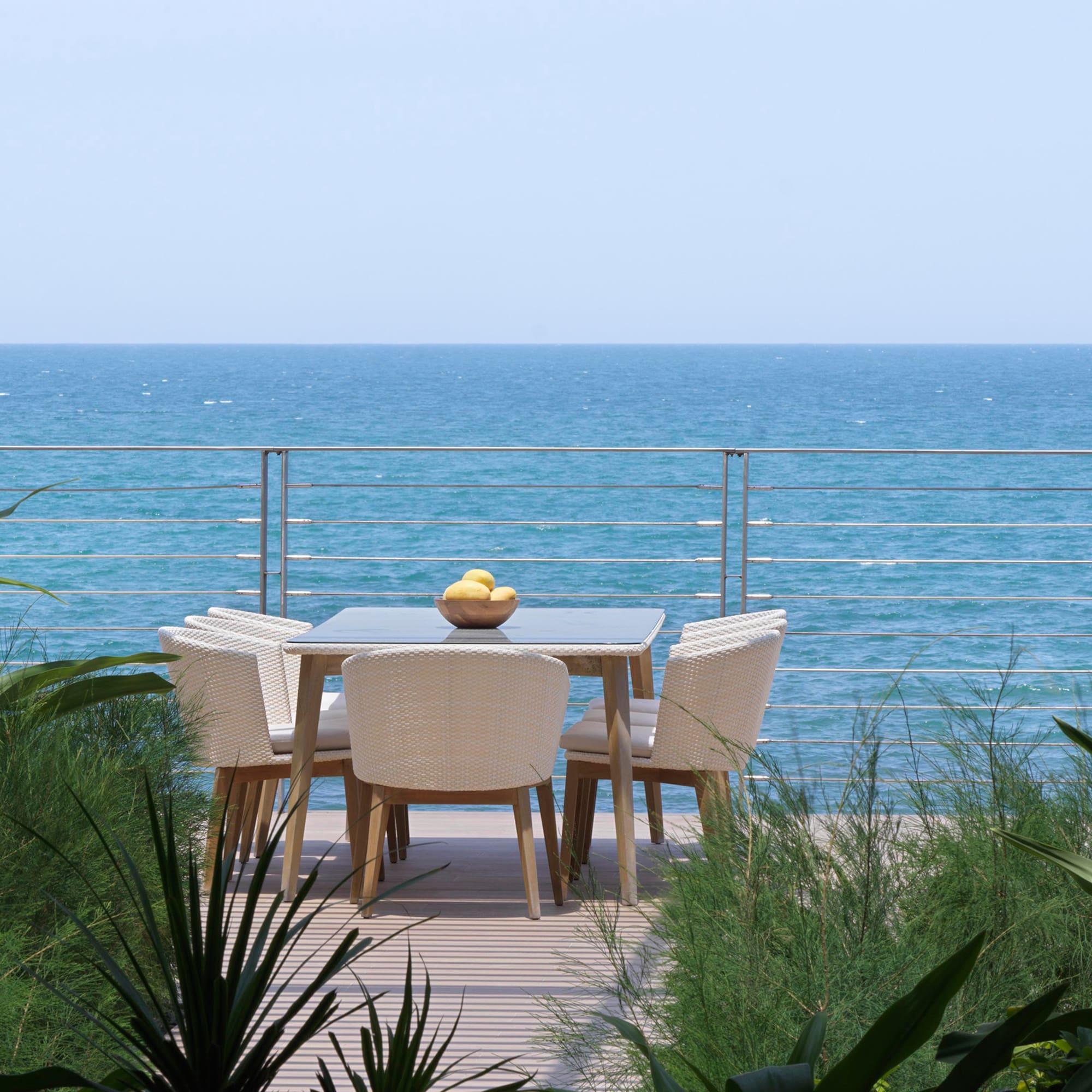 a table and chairs on a deck overlooking the ocean