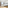 Bright modern hotel studio with bed, sofa, dining area, and wooden floor.