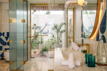 a bathroom with glass shower doors and plants
