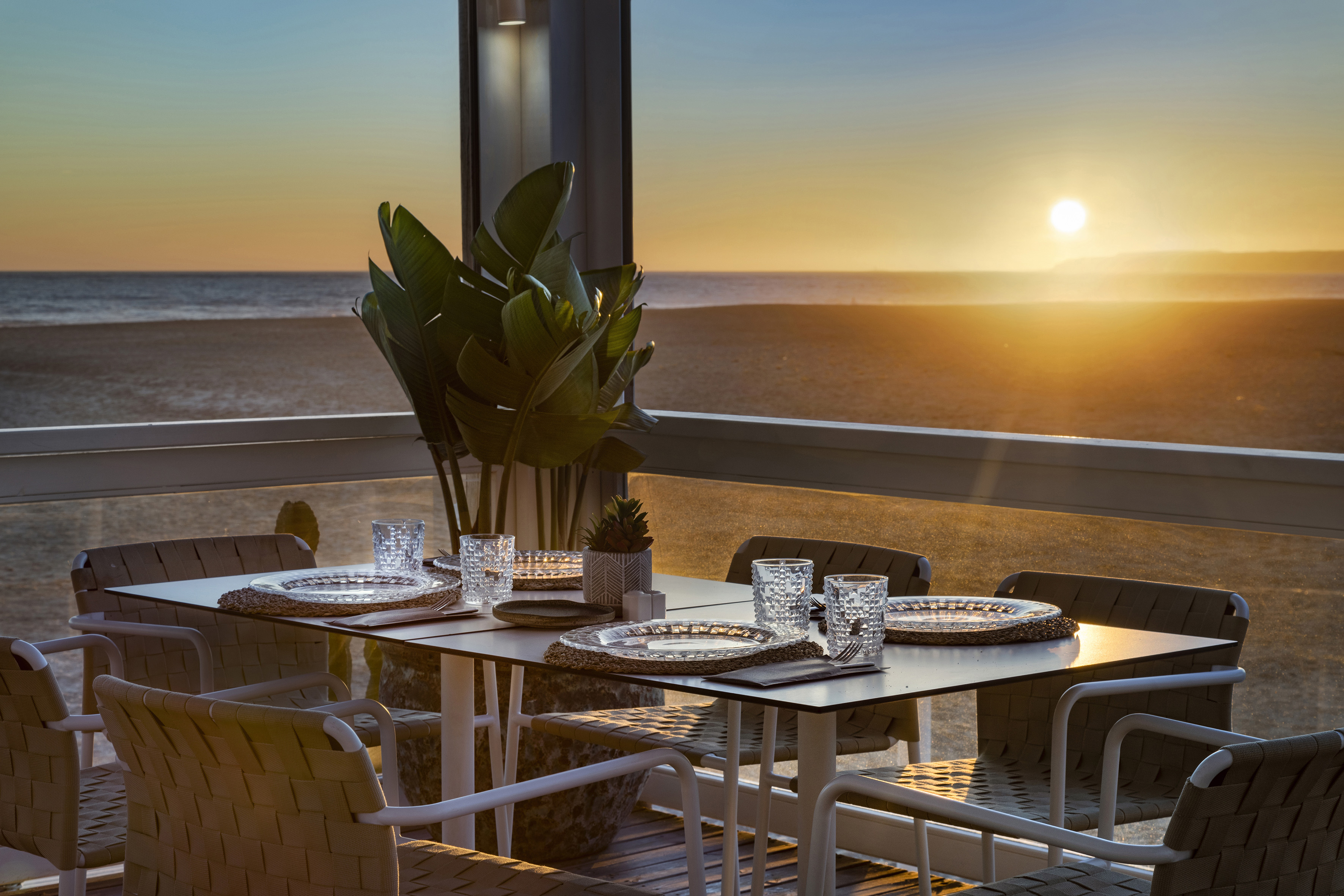 a table set up on a balcony overlooking the ocean