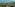High view of tropical resort villas, palm trees, sandy beach, and blue ocean.
