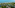 High view of tropical resort villas, palm trees, sandy beach, and blue ocean.
