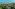 High view of tropical resort villas, palm trees, sandy beach, and blue ocean.