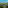 High view of tropical resort villas, palm trees, sandy beach, and blue ocean.