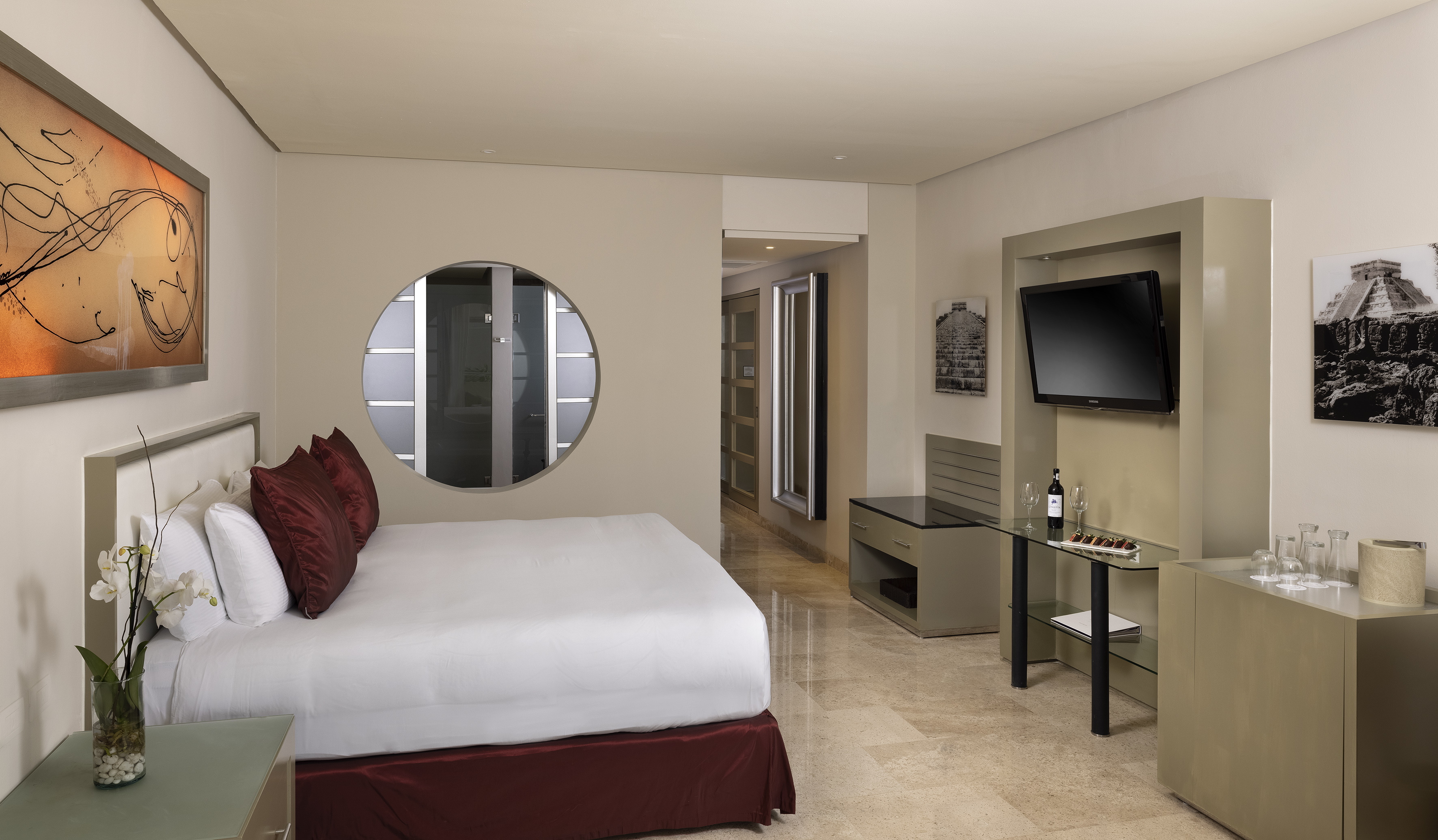 Modern hotel bedroom with king bed, TV, and contemporary decor.