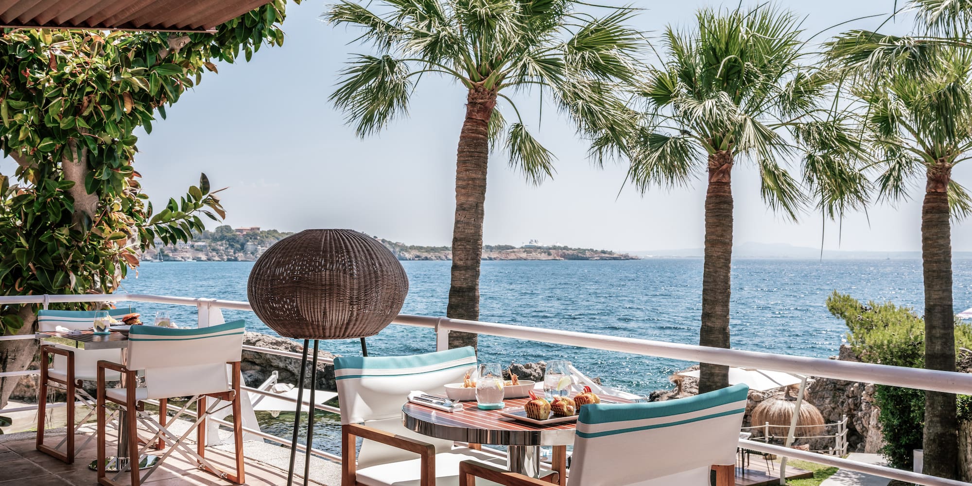 a table and chairs on a deck overlooking the water