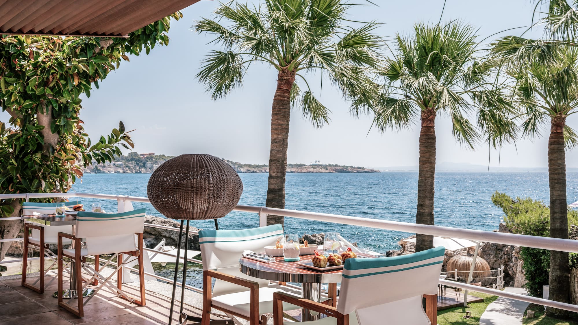 a table and chairs on a deck overlooking the water