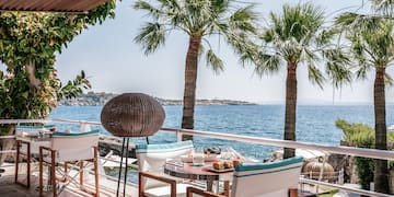 a table and chairs on a deck overlooking the water