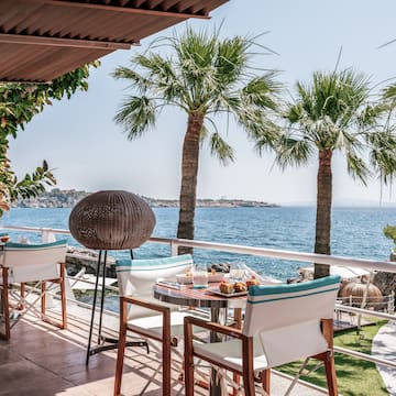 a table and chairs on a deck overlooking the water