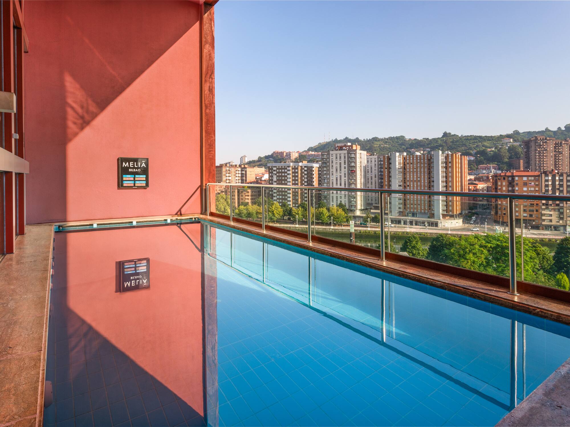 a pool with a balcony overlooking a city