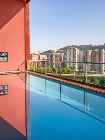 a pool with a balcony overlooking a city