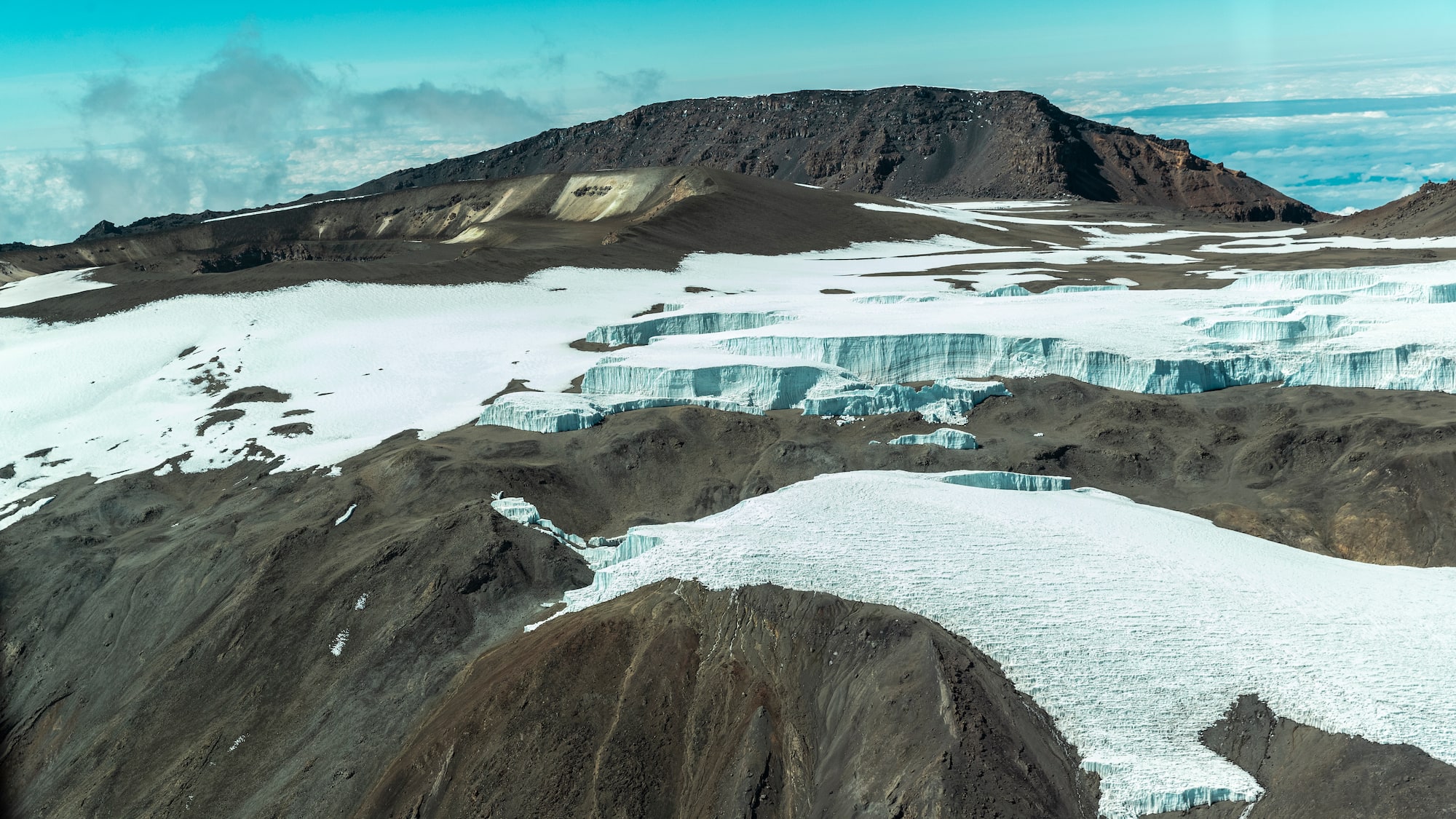 a snowy mountain with a mountain in the background