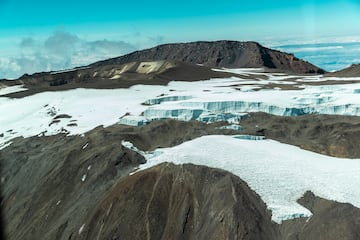 a snowy mountain with a mountain in the background