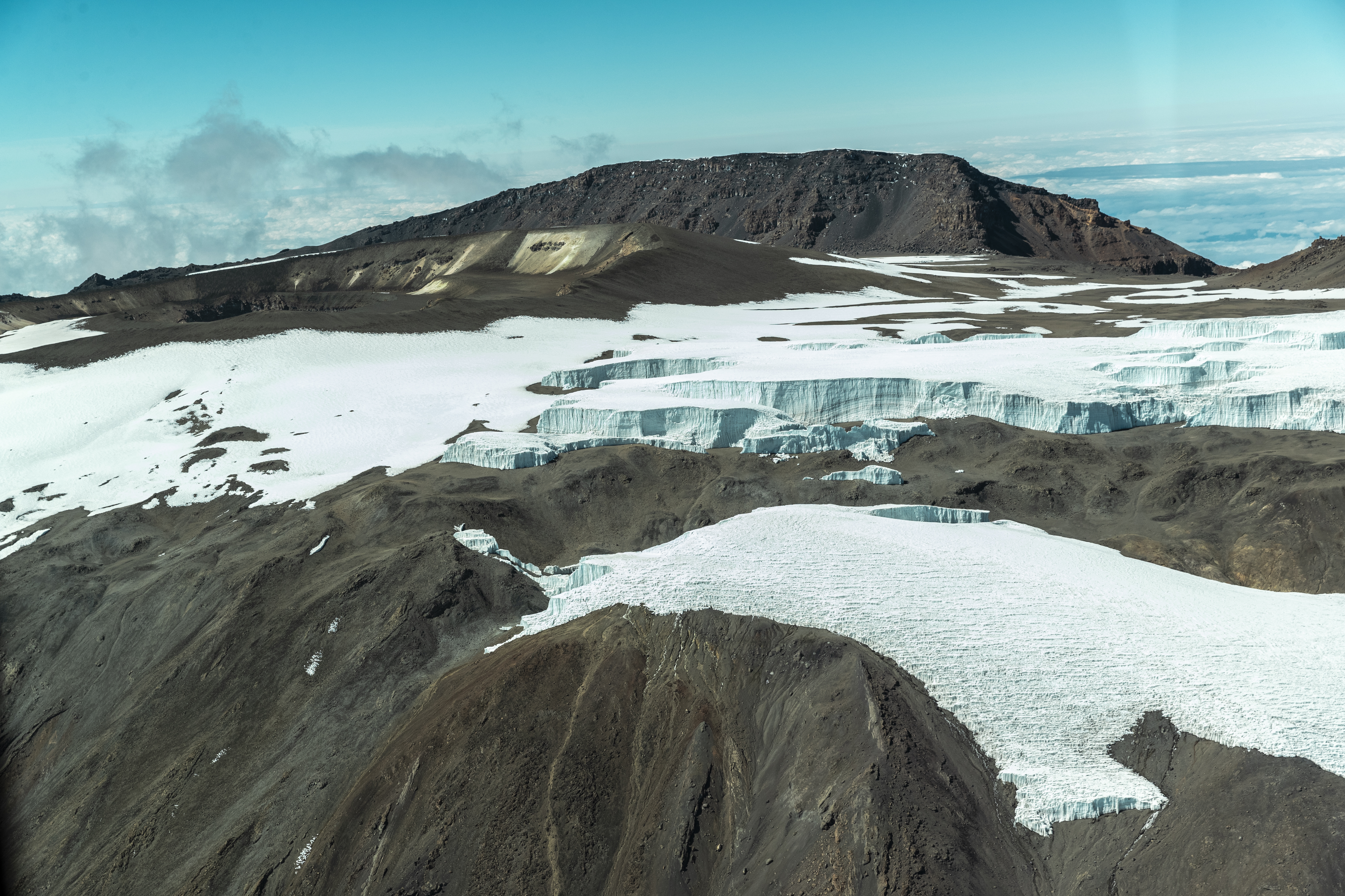 a snowy mountain with a mountain in the background