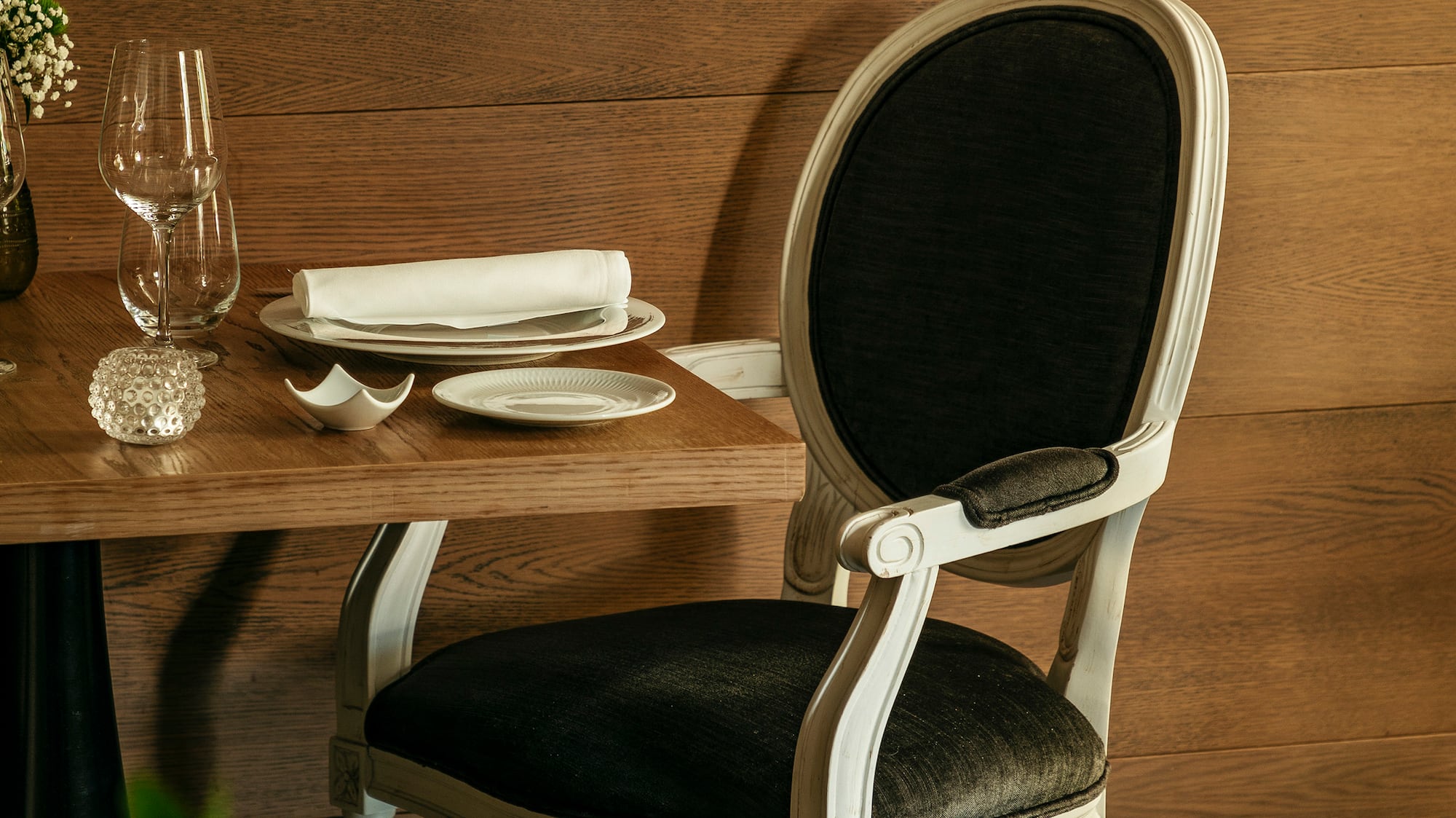 a chair and table with plates and glasses on it