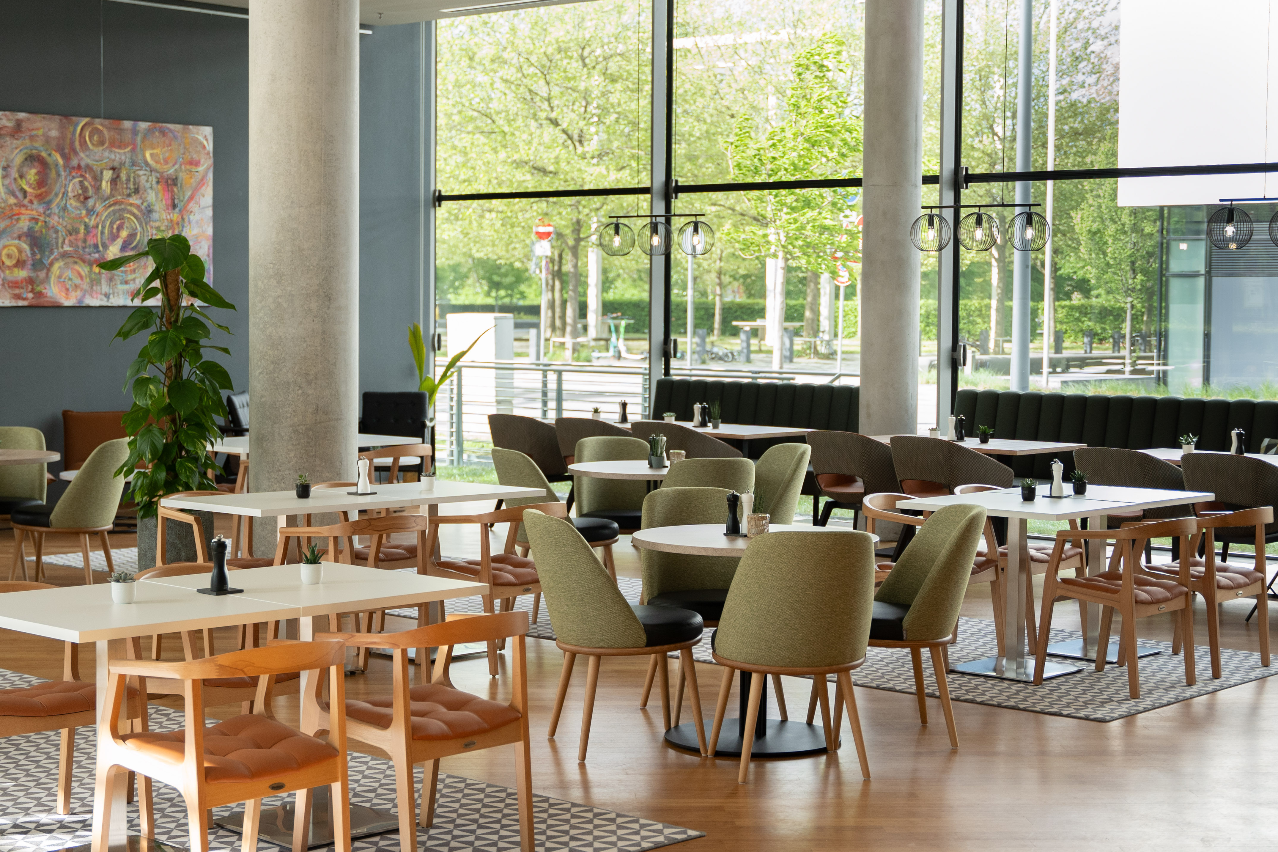 Modern cafe interior with green and wood seating, large windows.
