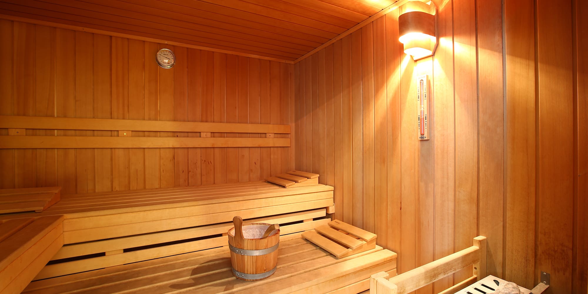 a wooden sauna with a bucket and a bench