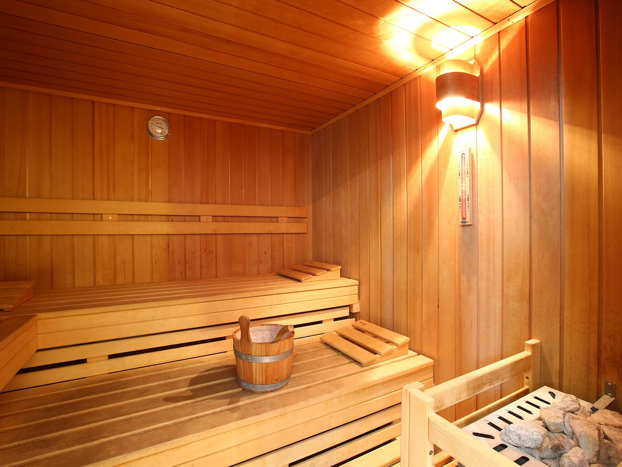 a wooden sauna with a bucket and a bench