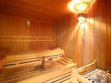 a wooden sauna with a bucket and a bench
