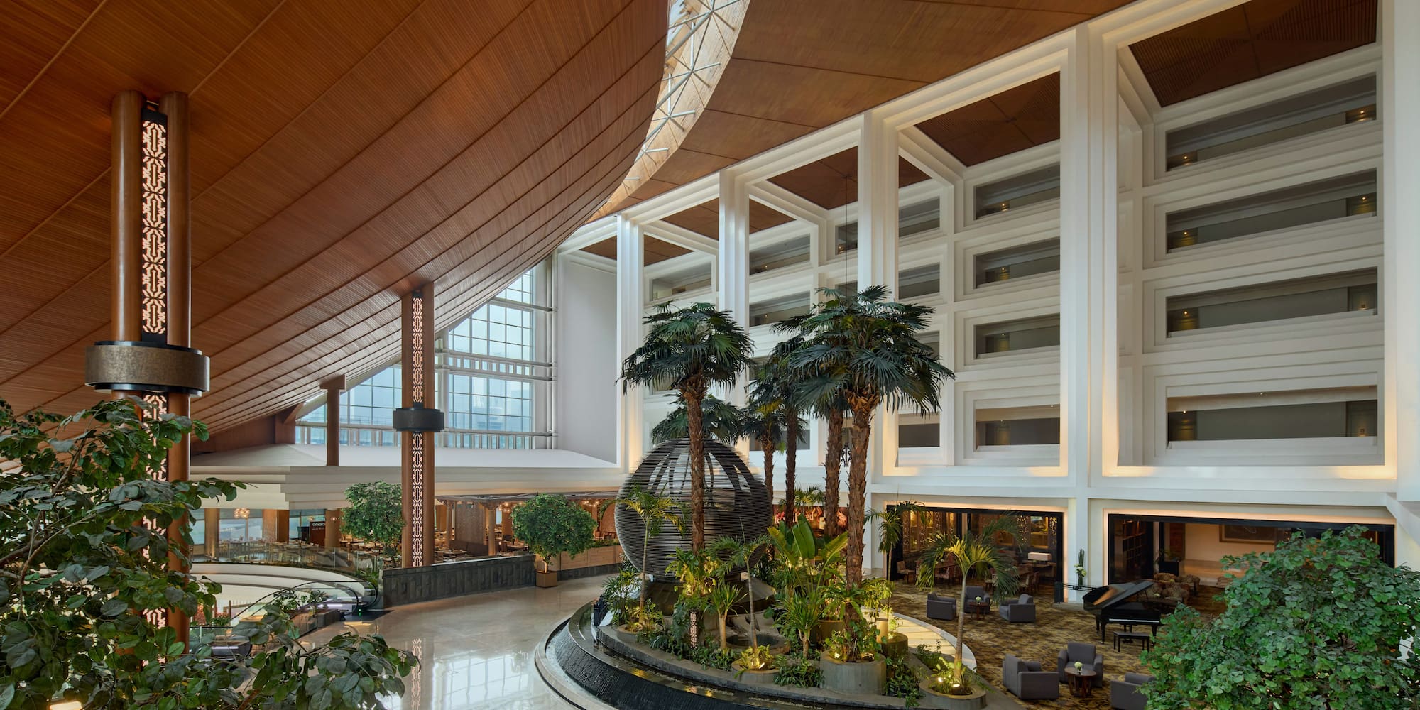 a large indoor building with a large round object with plants