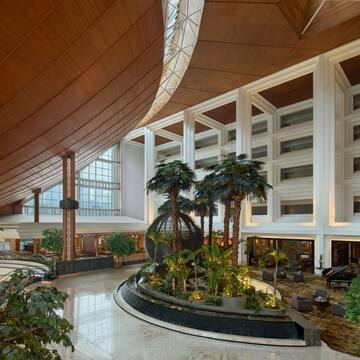 a large indoor building with a large round object with plants