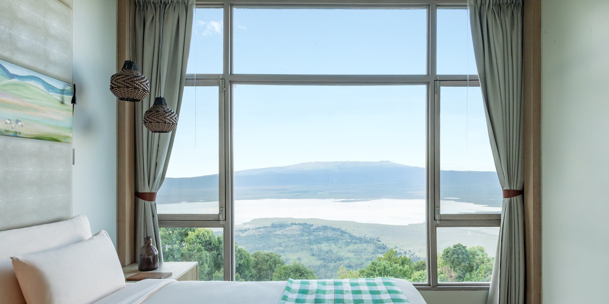a bedroom with a view of a mountain and a lake