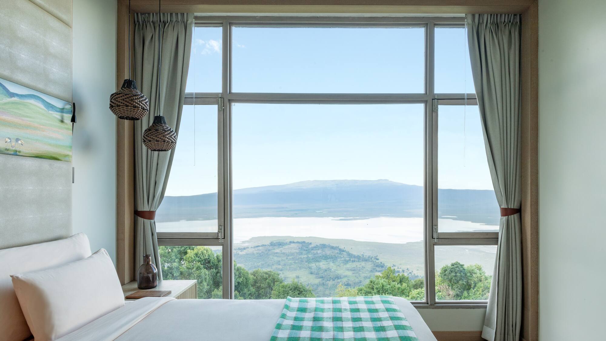 a bedroom with a view of a mountain and a lake