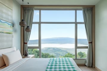 a bedroom with a view of a mountain and a lake