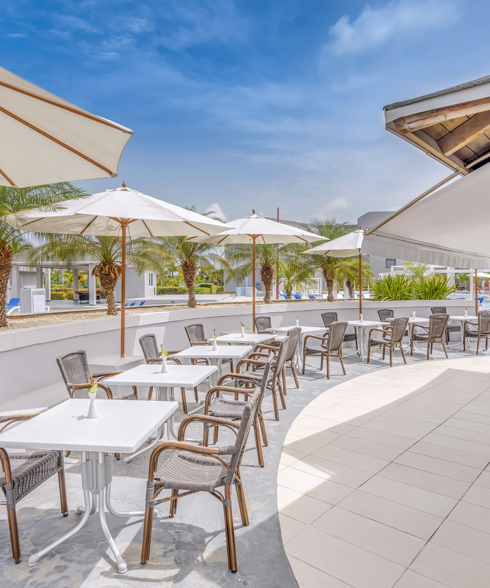 a patio with tables and chairs and umbrellas