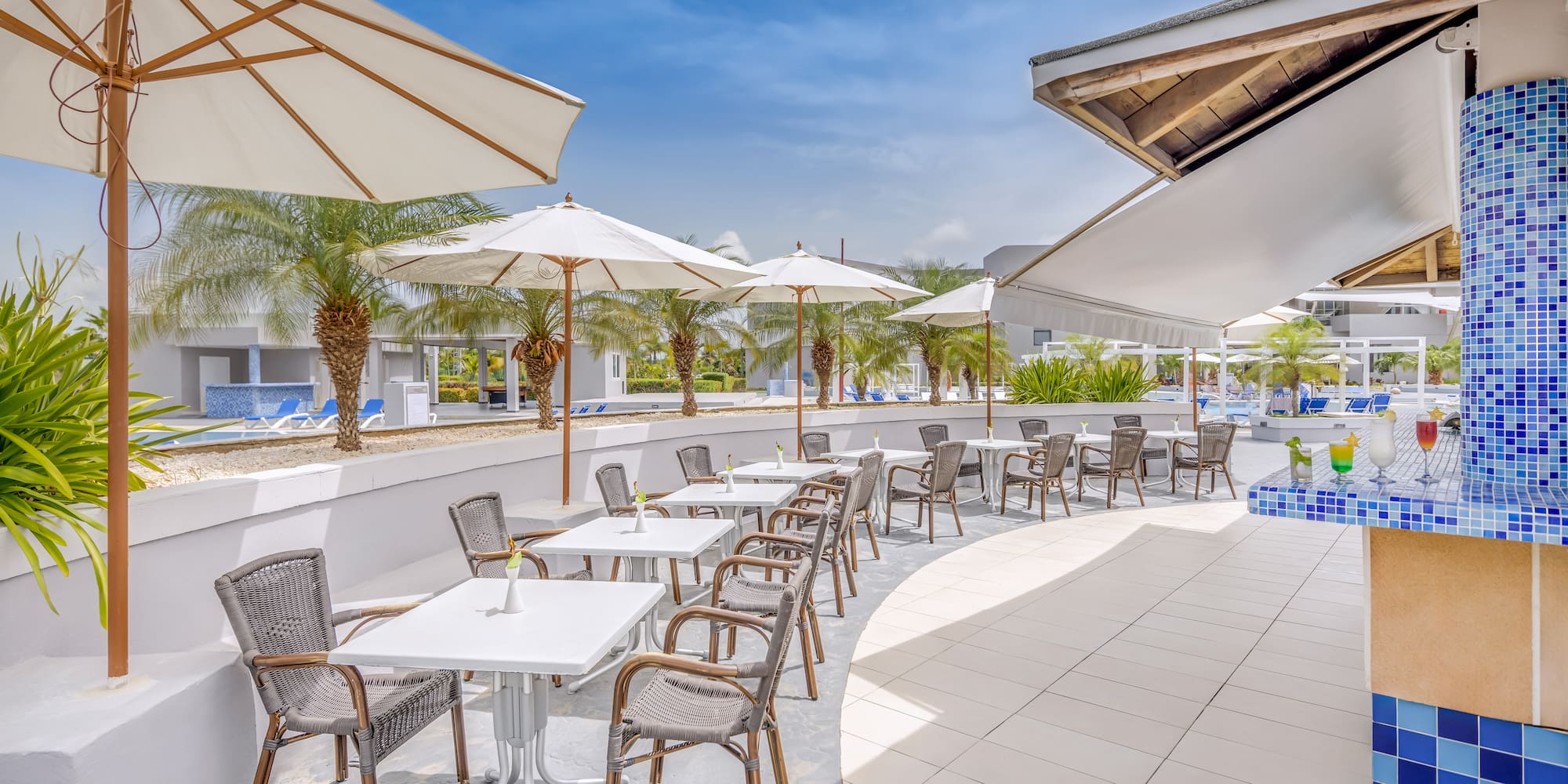 a patio with tables and chairs and umbrellas