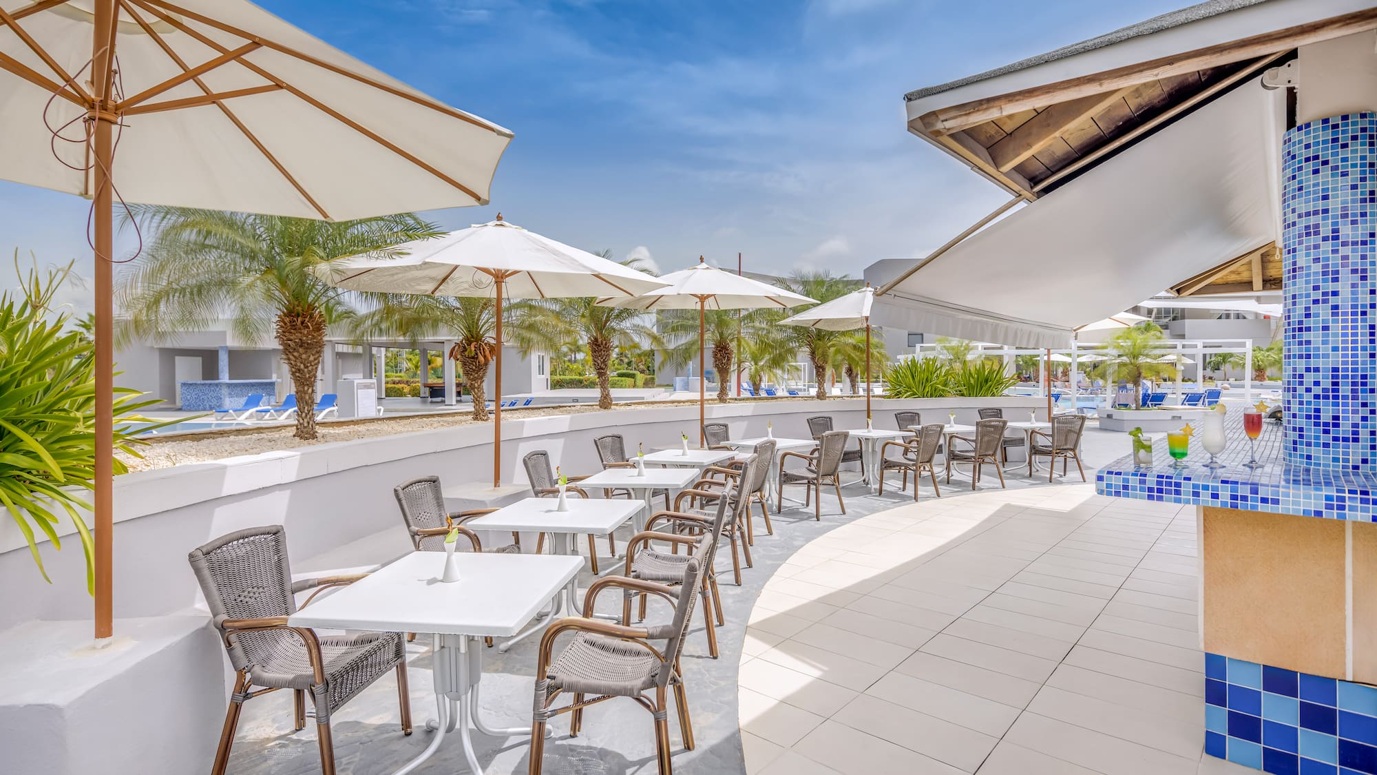 a patio with tables and chairs and umbrellas