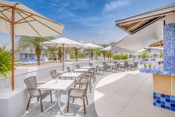 a patio with tables and chairs and umbrellas