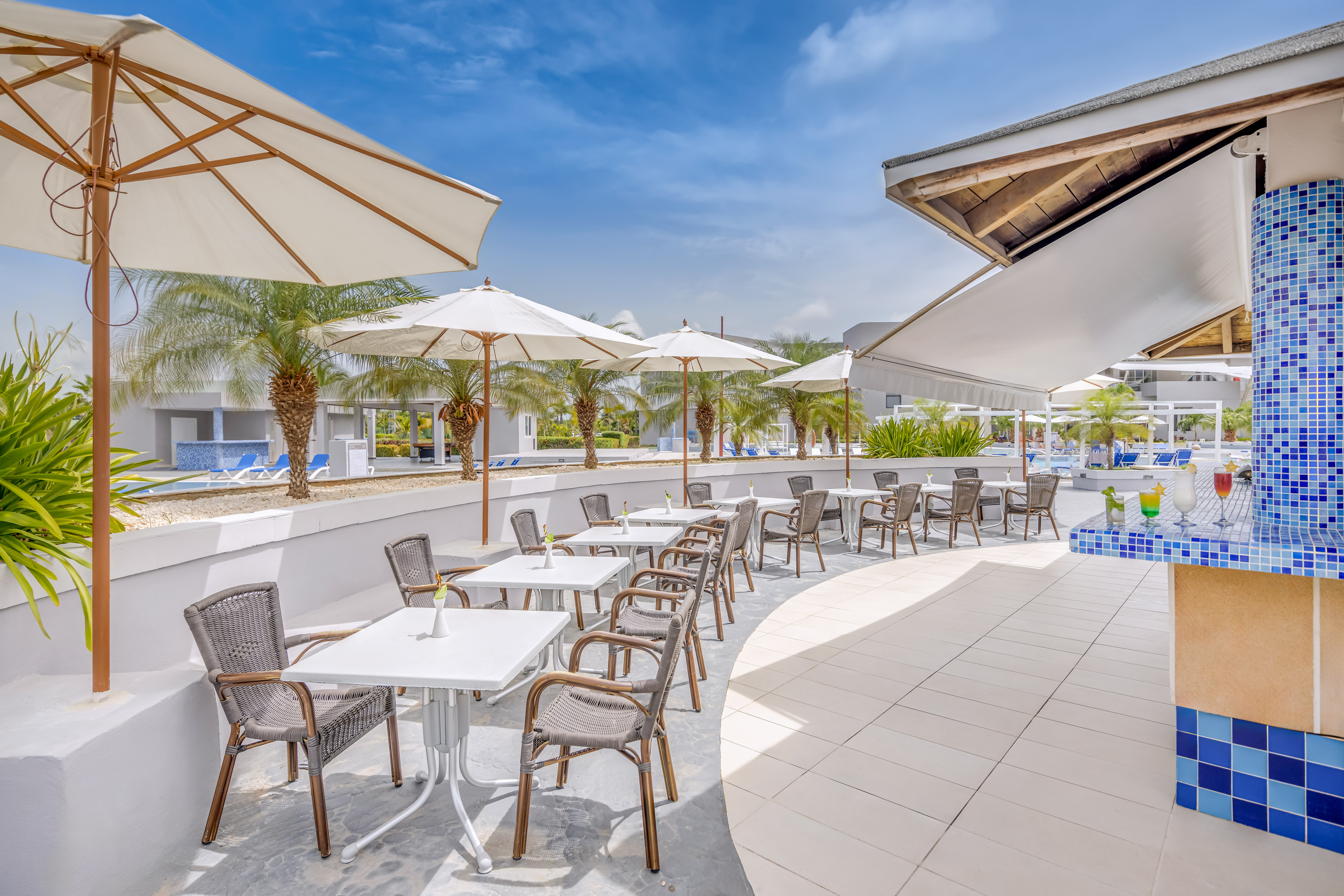 a patio with tables and chairs and umbrellas