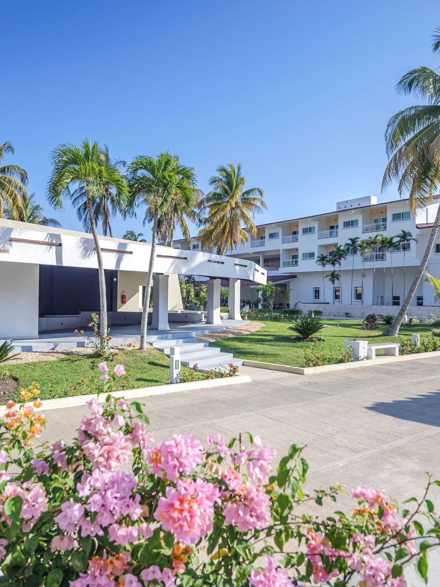 a building with palm trees and flowers