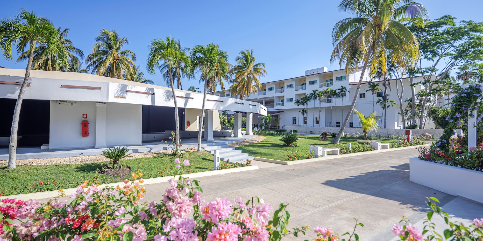 a building with palm trees and flowers