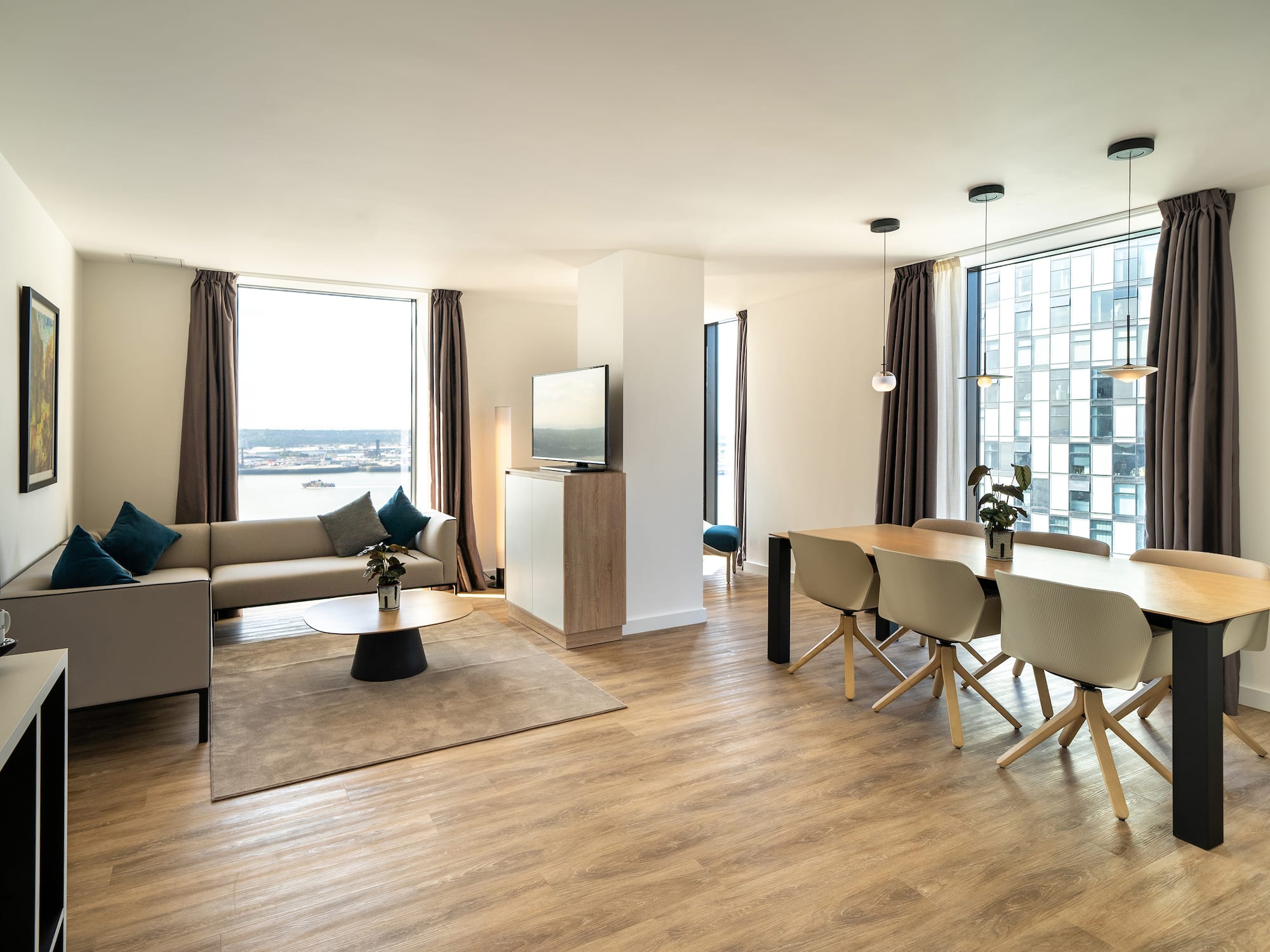 Bright, modern apartment living and dining space with city waterfront views.