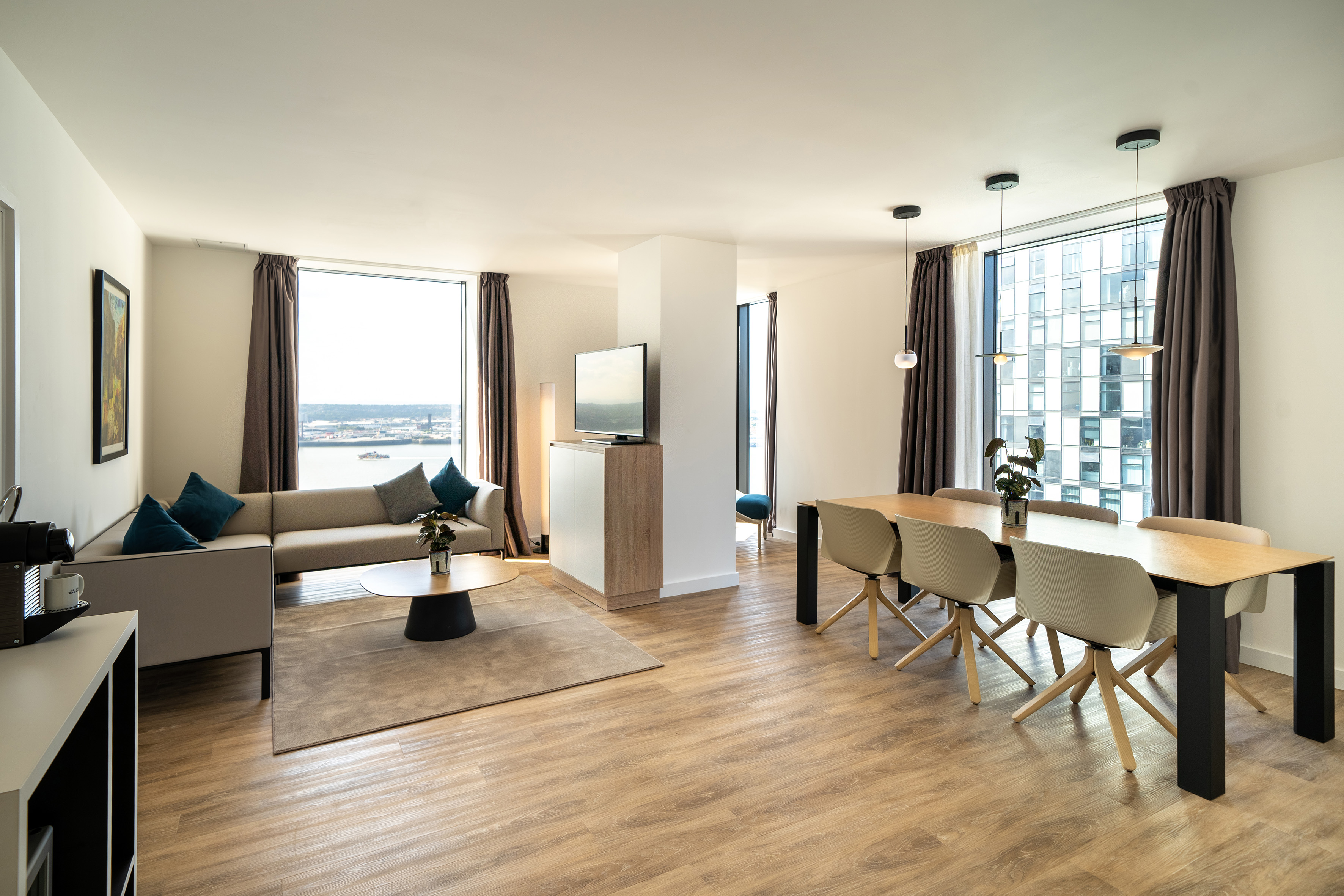 Bright, modern apartment living and dining space with city waterfront views.