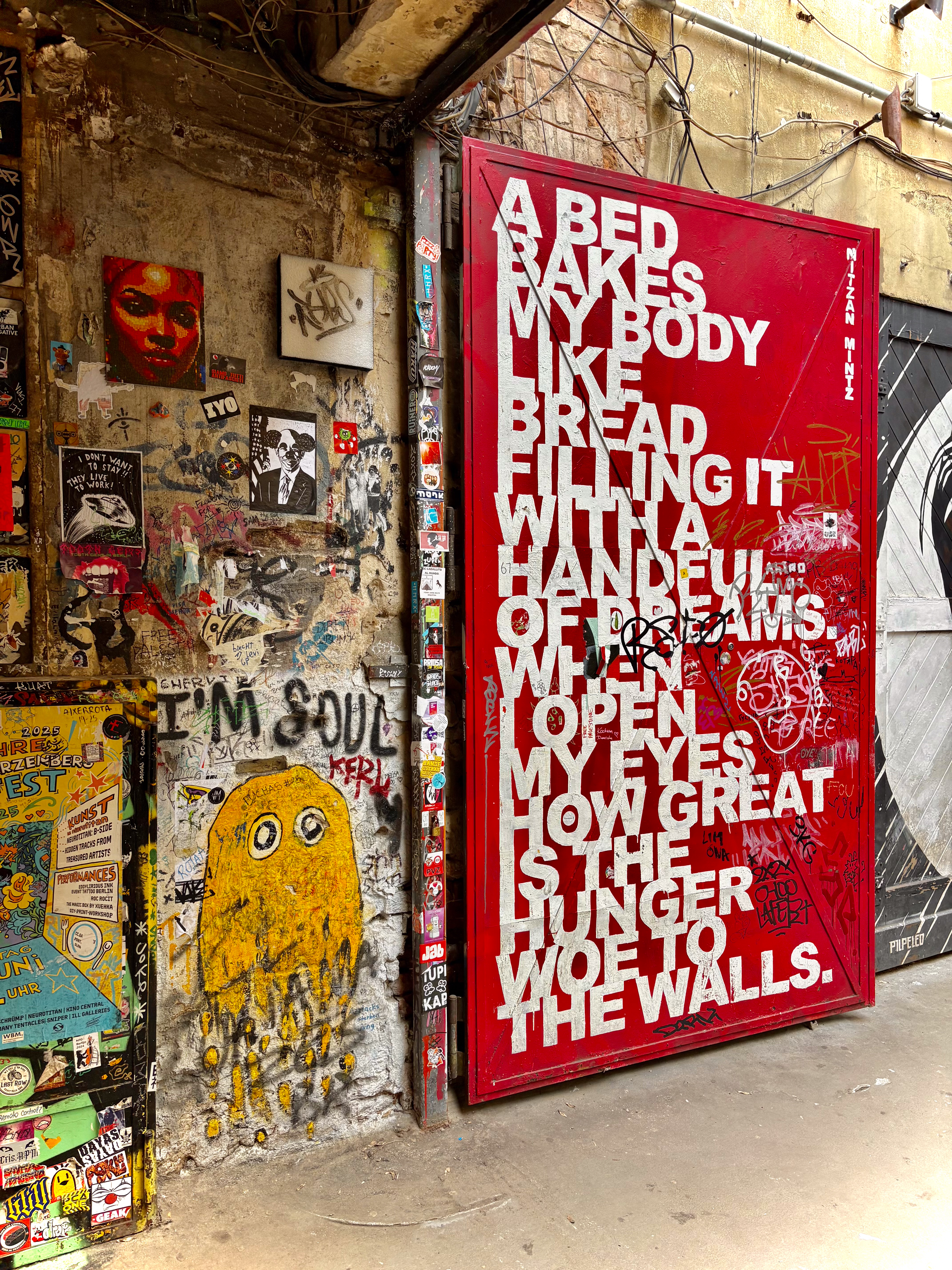 Red door street art with "A BED BAKES MY BODY" quote, grunge graffiti wall.