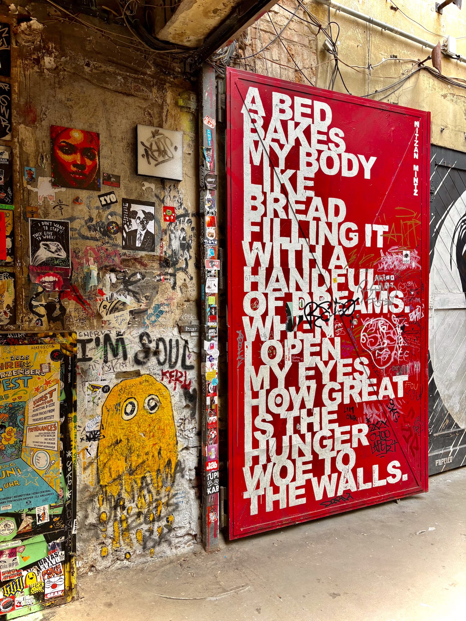 Red door street art with "A BED BAKES MY BODY" quote, grunge graffiti wall.