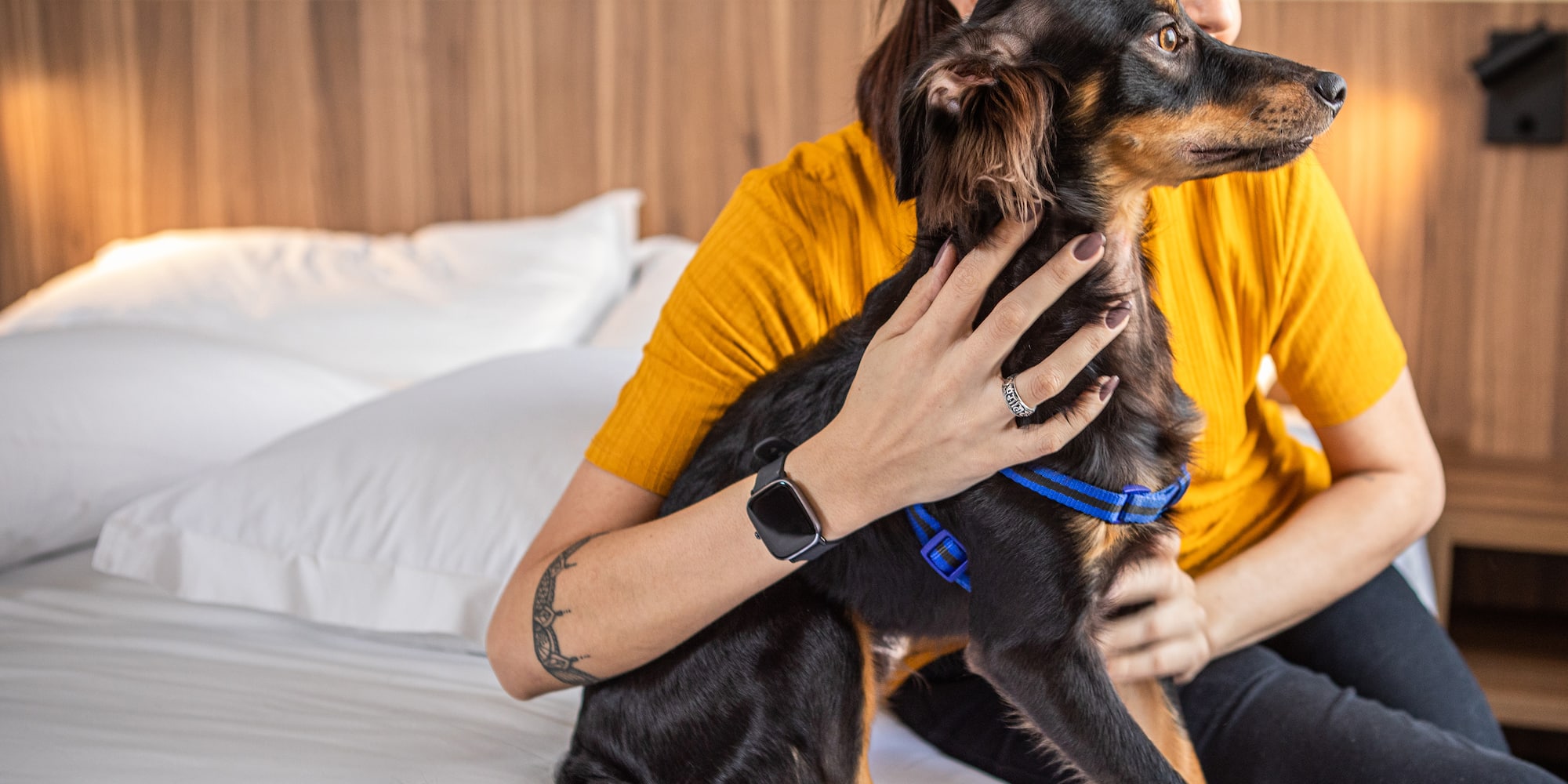 a woman sitting on a bed with a dog