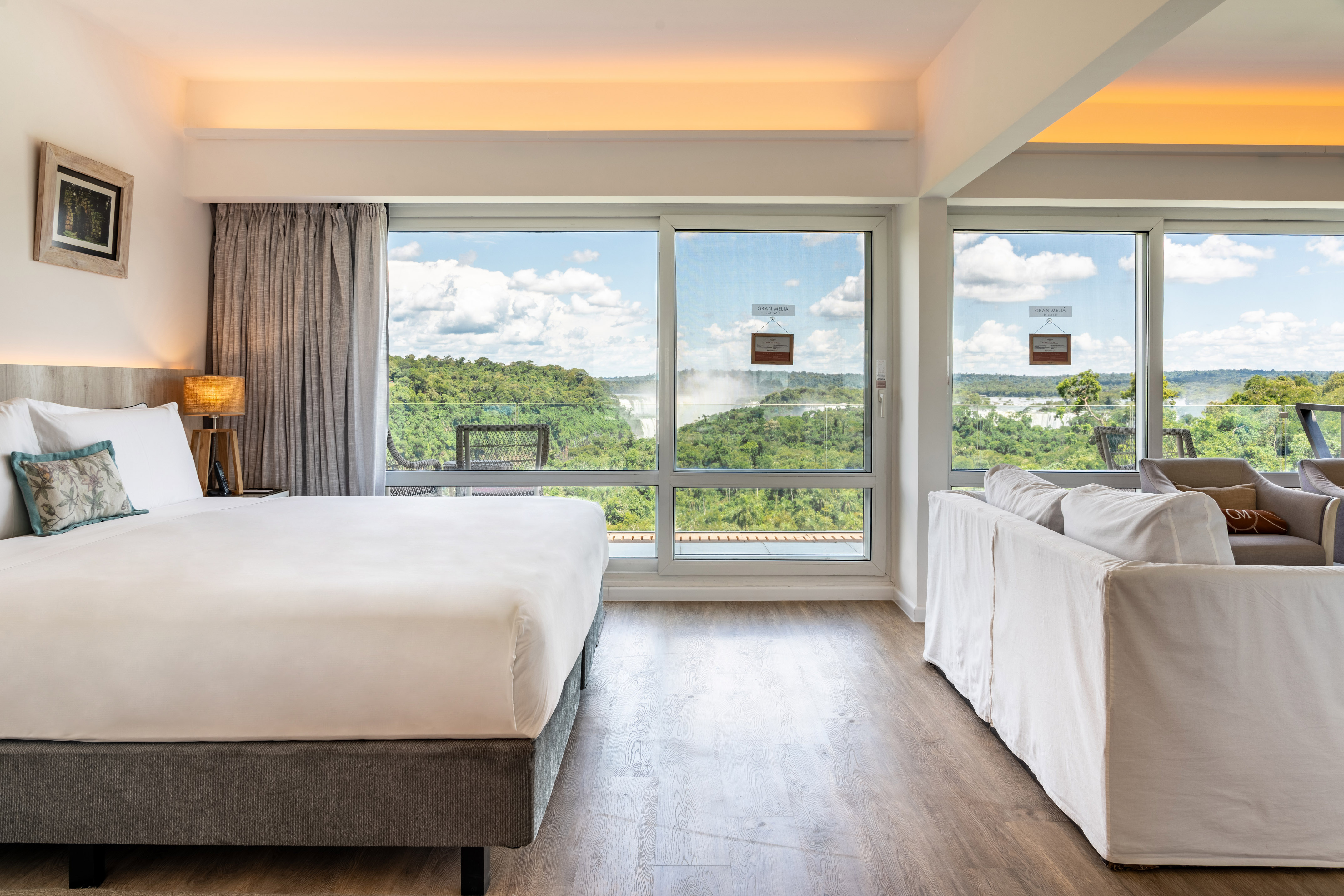 Gran Melia hotel suite with king bed, sofa, and stunning Iguazu Falls view.