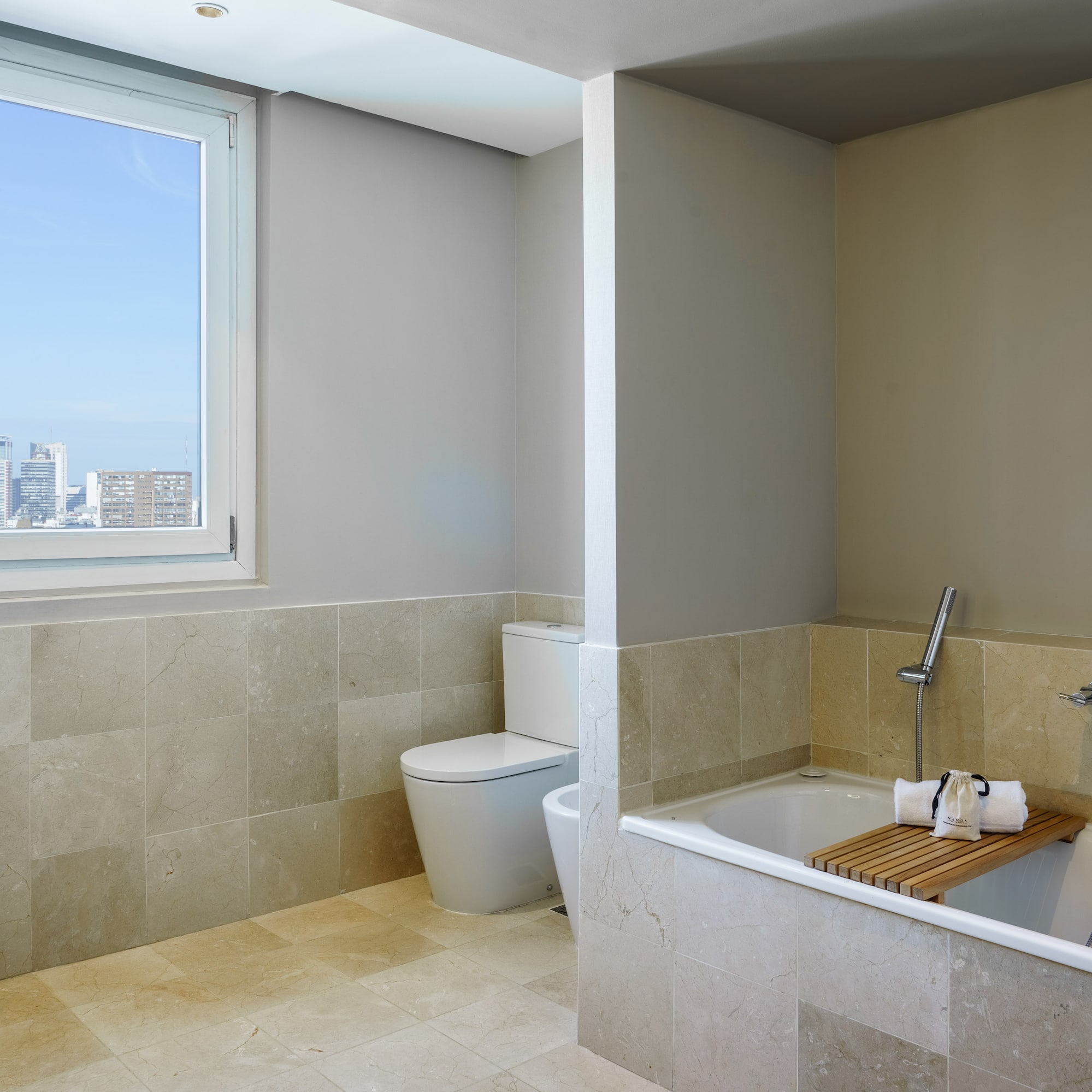 a bathroom with a tub toilet and a window