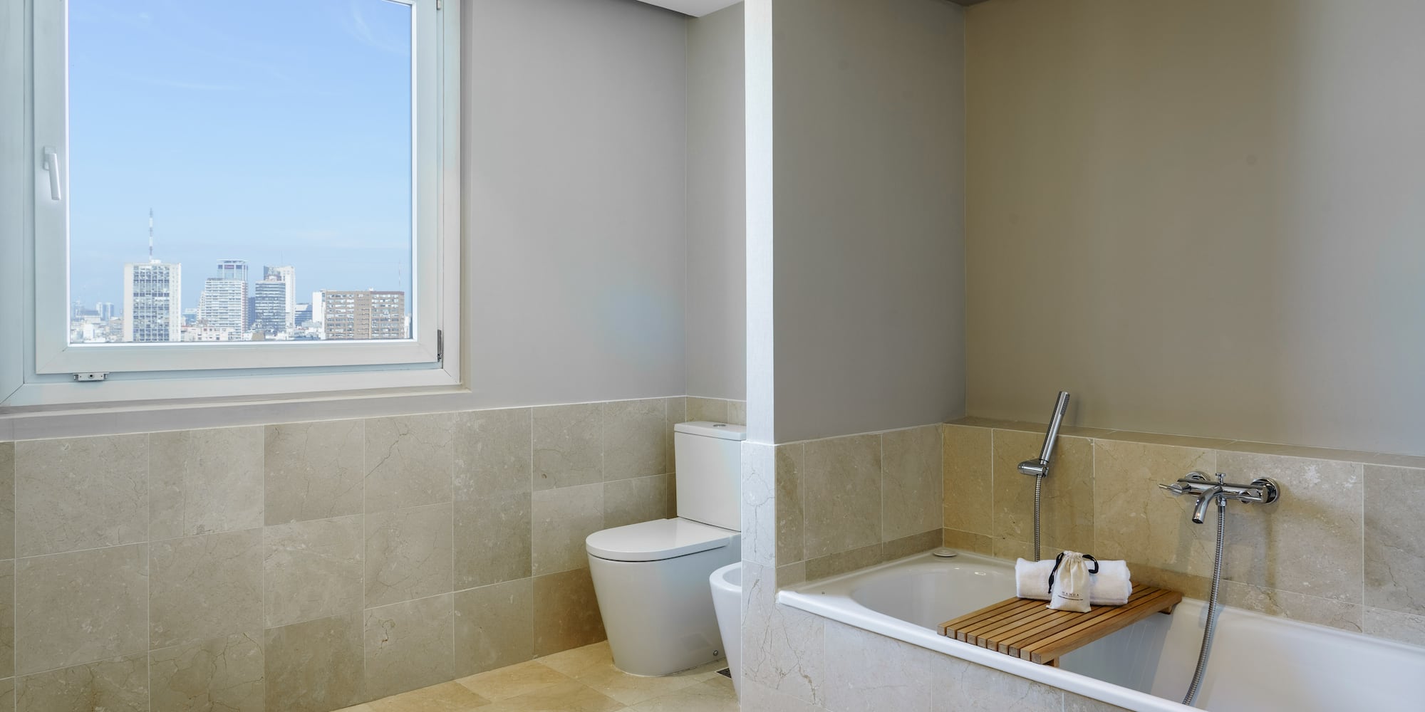 a bathroom with a tub toilet and a window