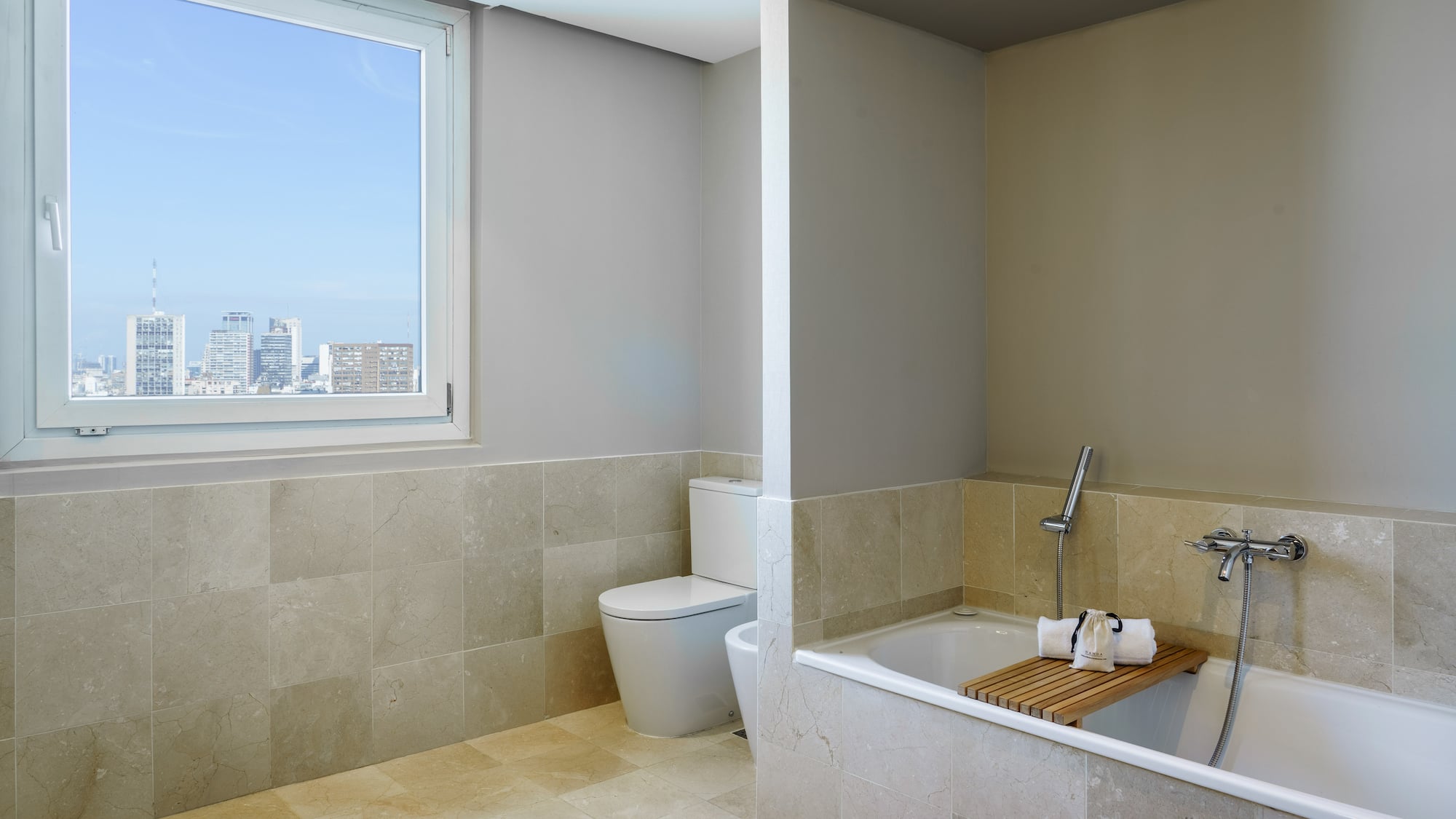a bathroom with a tub toilet and a window
