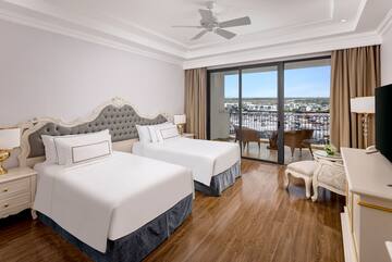 una camera con due letti, tavolo e sedie