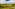 Tuscan vineyard landscape with rolling hills, olive trees, and distant farmhouse.