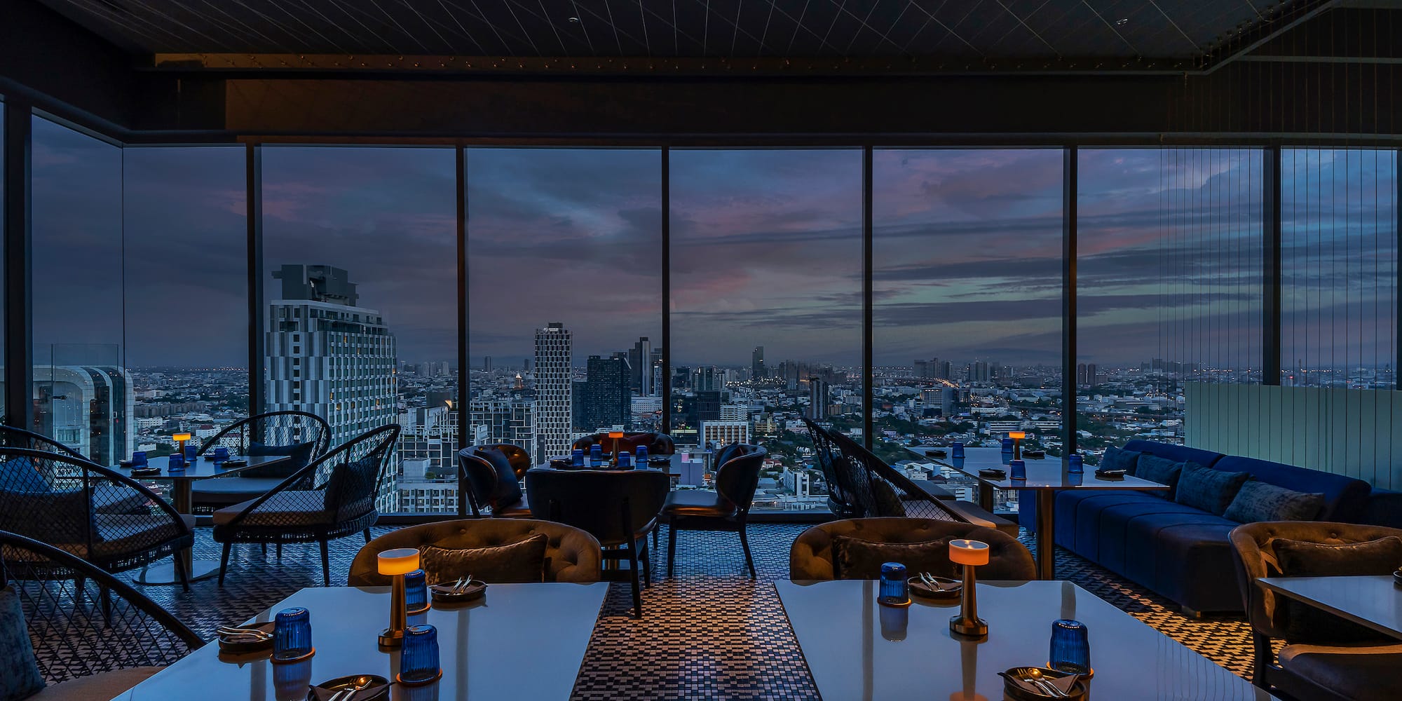 a room with tables and chairs and a view of a city